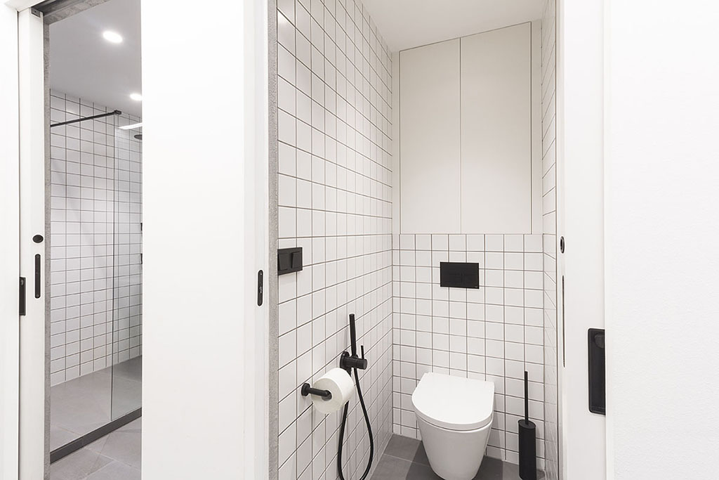 Návrh interiéru koupelny v kombinaci bílé a černé.