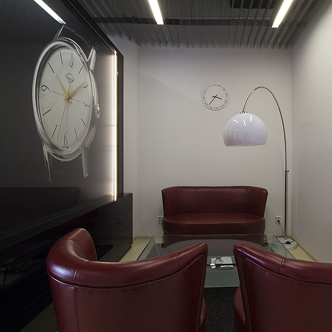 Design sezení sloužící pro předvádění hodinek v prodejně Prim Manufacture 1949 v Ostravě. Sezení je doplněno stojanovou lampou s bílým stínidlem.