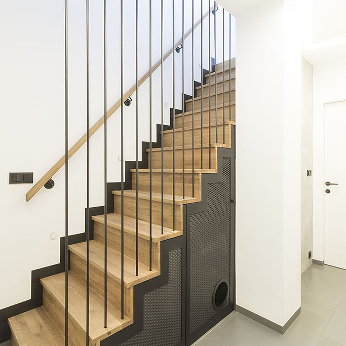 Design schodiště v kombinaci dubu a černého kovu s prvky z tahokovu.
