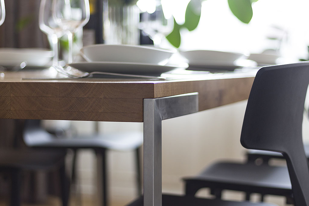 Detail ocelové podnože jídelního stolu s dubovou deskou.