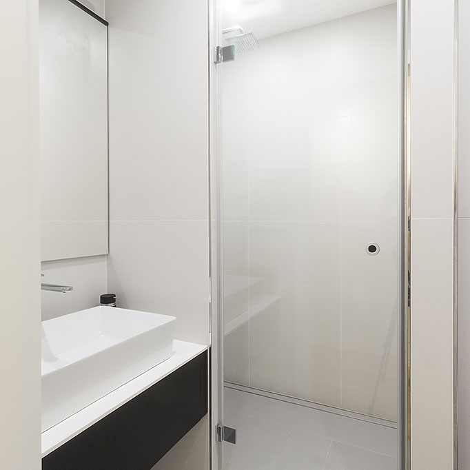 Design malé koupelny se sprchovým koutem v bílo šedém provedení.