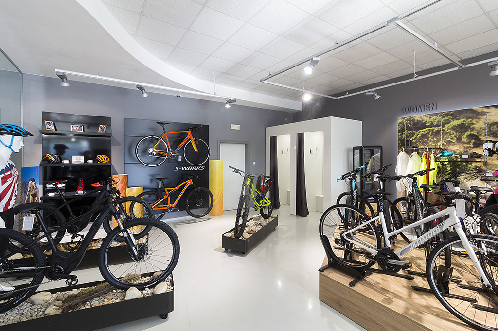 Design interiéru prodejny jízdních kol a doplňků s jednotlivými výstavními podii a výstavními stěnami.