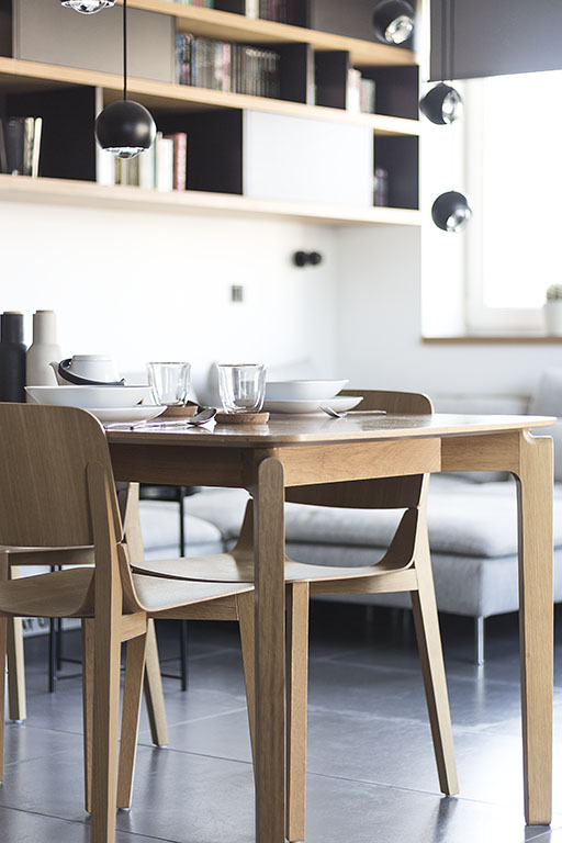 Design masivního dubového jídelního stolu Leaf od značky Ton doplněný židlemi Leaf stejné řady, vytváří útulný bytový design obývacího pokoje s jídelnou.